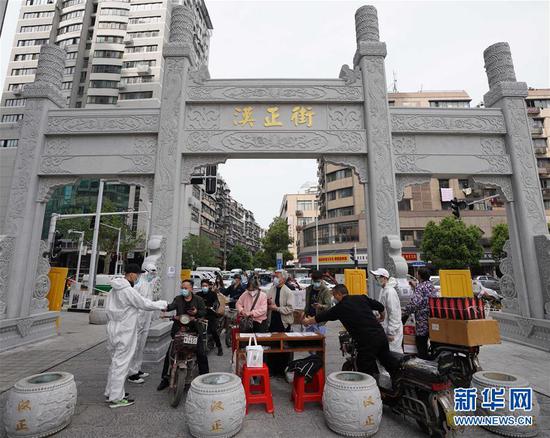  4月16日，進(jìn)出武漢漢正街步行街的人員在掃描健康碼。新華社記者 王毓國(guó) 攝